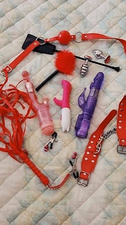 Flogger, gag, cuffs, clamps and toys laid out